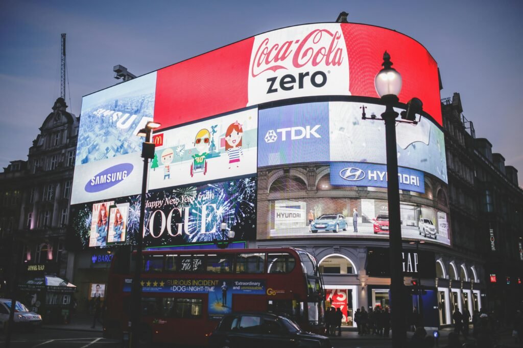 our services Night view of Piccadilly Circus in London with bright billboards and a red double-decker bus.